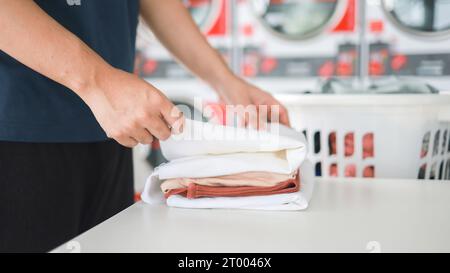 Mari de la maison avec panier et vêtements sales ou lavés à laundryÂ intérieur de la buanderie. lavage machineÂ à l'entreprise de blanchisserie stor Banque D'Images