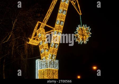 Grue de construction symbole de Shipyard Holiday décorations illuminées à Gdansk Pologne. Belle foire de Noël la nuit. Heure d'hiver de l'Avent à Europ Banque D'Images