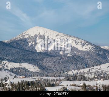 En hiver, les environs isolés des villages alpins, les collines de campagne, les bosquets et les terres agricoles offrent une vue depuis les pentes de montagne Banque D'Images