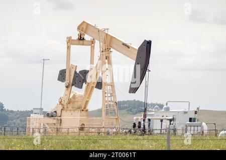 Calgary, Alberta, Canada. 7 août 2023. Un puits de production de pétrole brut, un site avec un vérin de pompage dans une zone rurale en été à Alb Banque D'Images