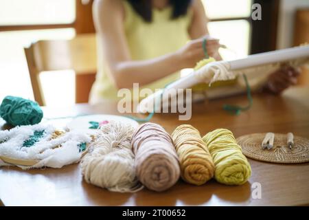 Aiguille perforée. Femme asiatique faisant tricoter Hobby à la main dans l'atelier de studio. Designer Workplace projet artisanal fait main DIY embro Banque D'Images