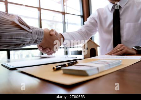 Les gens d'affaires signant le contrat faisant une affaire avec le concept d'agent immobilier pour le consultant et le concept d'assurance habitation. Banque D'Images