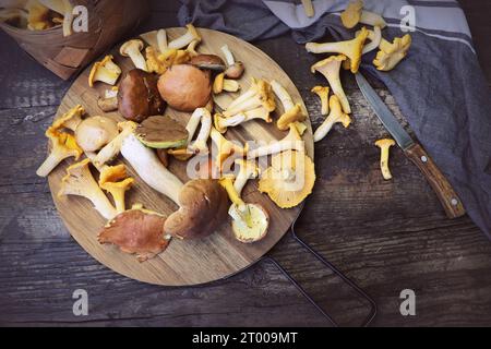 Mélange de champignons des bois sur une planche à découper plus vieille table en bois . Banque D'Images