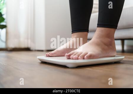 Régime gras et pieds de balance debout sur des balances électroniques pour le contrôle du poids. Instrument de mesure en kilogramme pour un contrôle de régime. Banque D'Images