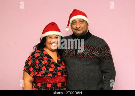 Couple latino avec le corps en surpoids positif portant des chapeaux de père noël sont heureux et excités à l'arrivée de décembre et célébrant Noël Banque D'Images