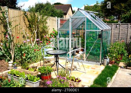 Nouvelle serre hybride moderne en polycarbonate avec une table et des chaises au premier plan, Somerset, Royaume-Uni, Europe Banque D'Images