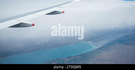 Vue aérienne du lac Pukaki dans un brouillard épais, depuis un avion volant d'Auckland à Queenstown. South Island. Nouvelle-Zélande. Banque D'Images