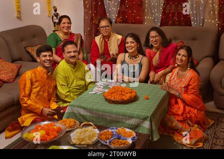 Famille heureuse en tenue traditionnelle célébrant Diwali ensemble à la maison Banque D'Images