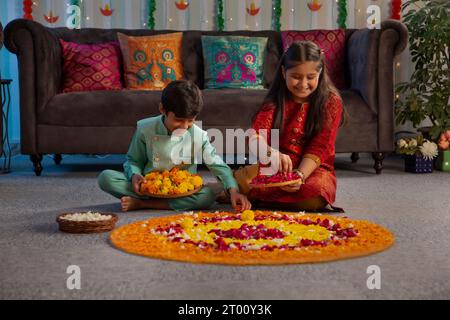 Enfants fabriquant des rangoli floraux à l'occasion de Diwali Banque D'Images