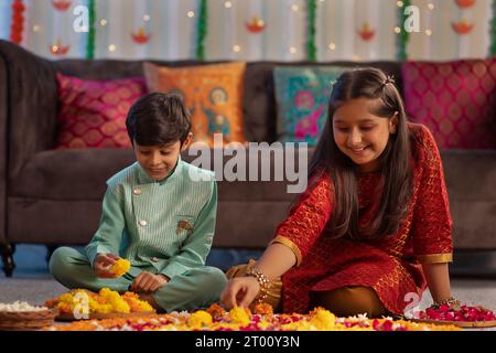 Enfants fabriquant des rangoli floraux à l'occasion de Diwali Banque D'Images