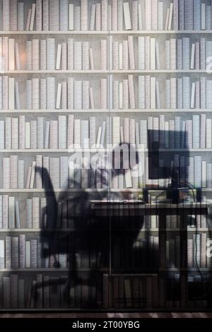 Un homme au travail sur un ordinateur derrière un écran imprimé, dans un immeuble de bureaux à Thornaby, North Yorkshire, Royaume-Uni. 19/07/2023. Photographie : Stuart Boulton. Banque D'Images