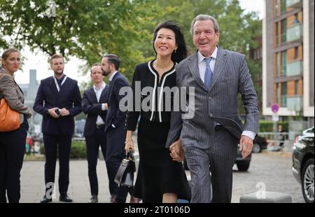 Hambourg, Allemagne. 03 octobre 2023. L'ancien chancelier allemand Gerhard Schröder (à droite) et son épouse So-yeon Schröder-Kim arrivent devant l'église principale de St. Michaelis (Michel) pour la célébration centrale de la Journée de l'unité allemande. Dans le cadre de sa présidence du Bundesrat, Hambourg accueille les célébrations centrales de la Journée de l'unité allemande sous la devise «Ouvrir les horizons». Crédit : Christian Charisius/dpa/Alamy Live News Banque D'Images