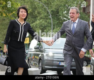 Hambourg, Allemagne. 03 octobre 2023. L'ancien chancelier allemand Gerhard Schröder (à droite) et son épouse So-yeon Schröder-Kim arrivent devant l'église principale de St. Michaelis (Michel) pour la célébration centrale de la Journée de l'unité allemande. Dans le cadre de sa présidence du Bundesrat, Hambourg accueille les célébrations centrales de la Journée de l'unité allemande sous la devise «Ouvrir les horizons». Crédit : Christian Charisius/dpa/Alamy Live News Banque D'Images