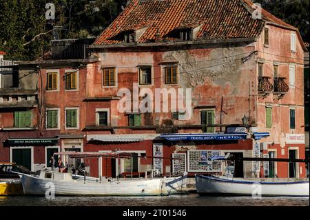 Le soleil d'été brille sur les toits traditionnels en tuiles, les façades roses lavées et un nom de bateau Morpheus à Omiš, une ville portuaire sur la côte Adriatique en Dalmatie, Croatie. Aujourd'hui, Omiš est une destination touristique populaire. Banque D'Images