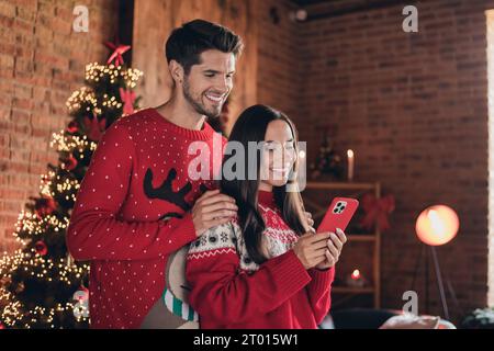 Photo de deux amis se soutenir mutuellement préparer la célébration acheter plus de cadeaux pour la famille magie 2024 Noël fête en utilisant le téléphone intérieur intérieur Banque D'Images