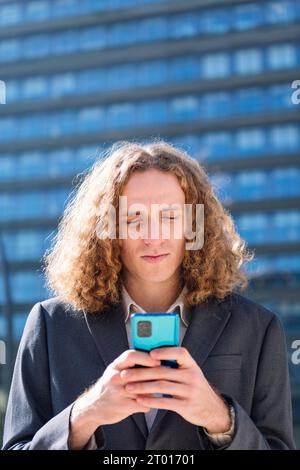homme d'affaires moderne tapant sur le téléphone portable à l'extérieur Banque D'Images