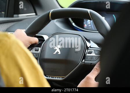 Mains sur le volant, une personne conduit la voiture avec confiance et contrôle tout en naviguant Banque D'Images