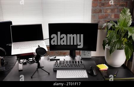 Podcasting mis en place avec des ordinateurs, clavier et microphone sur le bureau avec l'usine à la maison Banque D'Images