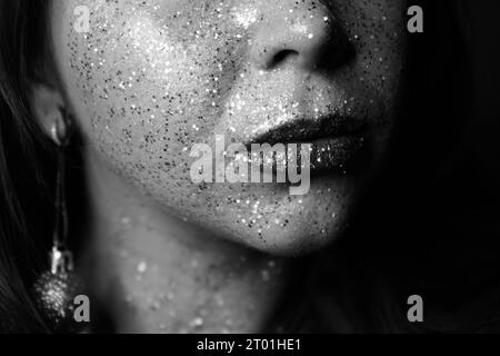 Portrait d'une belle femme avec des étincelles bleues sur son visage. Fille avec maquillage artistique coloré avec paillettes. Modèle de mode avec maquillage coloré. FE Banque D'Images