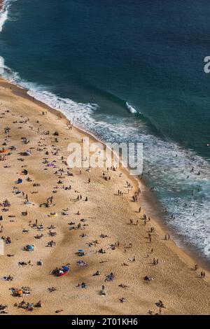 Vue aérienne des baigneurs de soleil et des nageurs profitant de la plage de Praia de Nazare, Portugal Banque D'Images