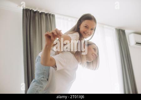 Une belle petite fille et sa mère aiment le soleil matin. Bon séjour à la maison. Banque D'Images