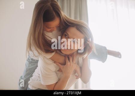 Une belle petite fille et sa mère aiment le soleil matin. Bon séjour à la maison. Banque D'Images