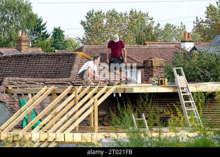 Constructeurs travaillant sur une extension de toit à un bungalow de banlieue à Shepperton Surrey Angleterre Banque D'Images