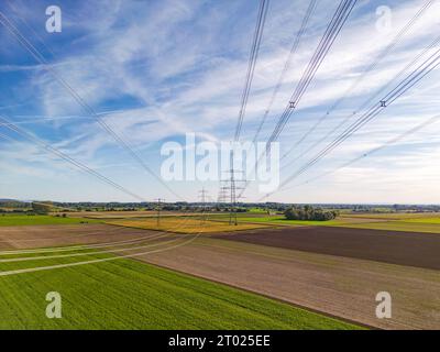 Paysage naturel rural en conflit avec les structures artificielles des poteaux électriques et des lignes électriques pour l'énergie pour la société de consommation comme plan aérien Banque D'Images