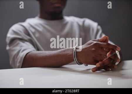Gros plan d'un jeune homme noir portant des menottes comme criminel arrêté, espace de copie Banque D'Images