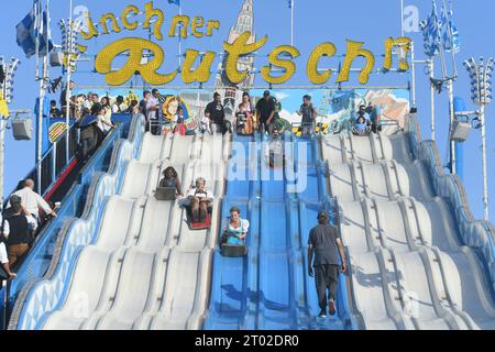Munich, Allemagne. 03 octobre 2023. Les visiteurs de l'Oktoberfest glissent sur le 'Münchner' Rutschn' à la fin de la 188e Oktoberfest de Munich. La 188e Wiesn aura lieu cette année jusqu’au 03.10.2023. Crédit : Felix Hörhager/dpa/Alamy Live News Banque D'Images