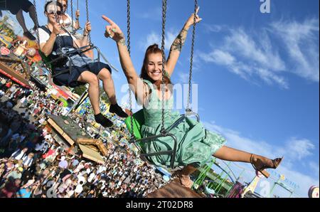 Munich, Allemagne. 03 octobre 2023. Le chorégraphe Tiger Kirchharz monte sur un carrousel à chaînes à la fin de la 188e Oktoberfest de Munich sur la Theresienwiese. La 188e Wiesn aura lieu cette année jusqu’au 03.10.2023. Crédit : Felix Hörhager/dpa/Alamy Live News Banque D'Images