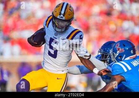 Oxford, Mississippi, États-Unis. 30 septembre 2023. Le quarterback Jayden Daniels de la LSU Tigers tente d'éviter d'être attaqué par deux défenseurs des Mississippi Rebels pendant le premier quart d'un match de football universitaire au Vaught-Hemingway Stadium à Oxford, Mississippi. Austin McAfee/CSM/Alamy Live News Banque D'Images