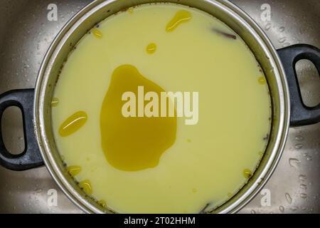 Beurre vert de marijuana fabriqué dans une casserole métallique dans une cuisine sale Banque D'Images