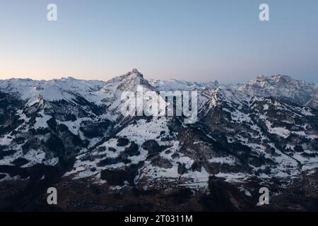 Un lever de soleil coloré sur le lac Walen dans le canton de Glaris en Suisse. En arrière-plan les montagnes enneigées. Banque D'Images