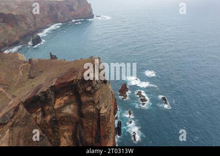 Superbe photo drone des falaises de Madère qui sont faites de roche volcanique et sont donc de couleur rougeâtre. Banque D'Images