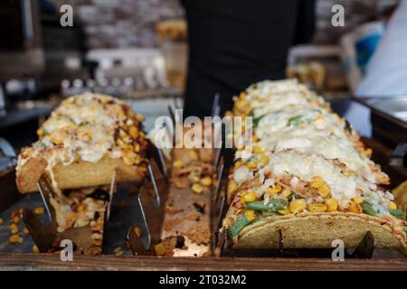 Attention sélective à la rangée de tacos de bœuf et de poulet sur le stand de nourriture mexicaine au marché extérieur de Street food. Banque D'Images