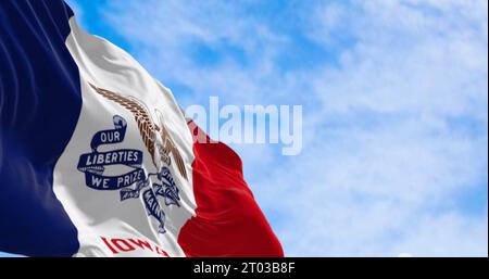 Drapeau de l'État de l'Iowa agitant dans le vent par temps clair. Trois bandes verticales de bleu, blanc et rouge, avec un aigle chauve au centre. illustration 3d réf Banque D'Images