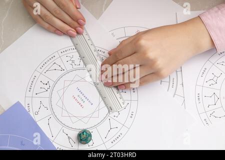 Astrologue utilisant la roue du zodiaque pour la prévision de destin à la table, vue de dessus. Dire la fortune Banque D'Images