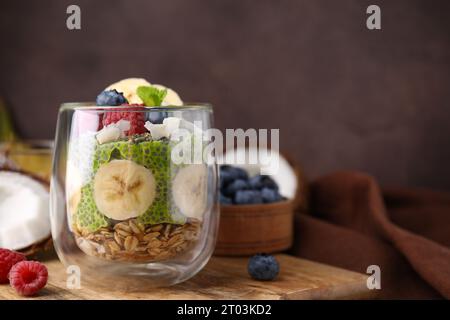 Savoureux flocons d'avoine avec du pudding chia matcha et des fruits sur une planche de bois, espace pour le texte. Petit déjeuner sain Banque D'Images