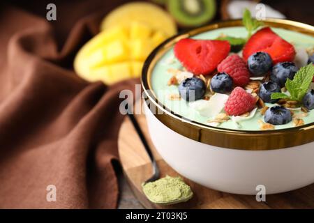 Savoureux bol de smoothie matcha servi avec des baies et des flocons d'avoine sur la table, gros plan avec espace pour le texte. Petit déjeuner sain Banque D'Images