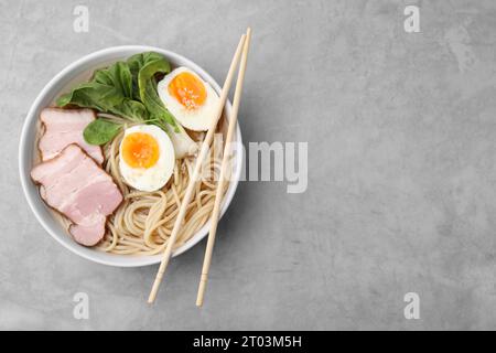 Délicieux ramen avec de la viande sur la table gris clair, vue de dessus et espace pour le texte. Soupe de nouilles Banque D'Images