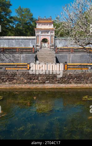 Vietnam : porte menant à la tombe de l'empereur Tu Duc, Hué. L'empereur Tự Đức (22 septembre 1829 – 17 juillet 1883) (nom complet : Nguyễn Phúc Hồng Nhậm, également Nguyen Phuc Thi) est le quatrième empereur de la dynastie Nguyễn du Vietnam et règne de 1847 à 1883. Fils de l'empereur Thiệu Trị, le prince Nguyễn Phúc Hồng Nhậm succède à son père sur le trône, avec le titre régnant de Tự Đức, mais des problèmes familiaux provoquent un début violent de son ère. Thiệu Trị avait passé sur son fils aîné plus modéré, Hồng Bảo, pour donner le trône à Tự Đức. Banque D'Images