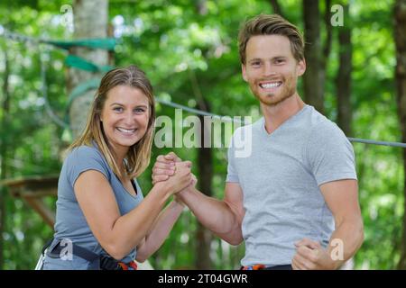 jeune homme et femme bras de fer pendant le cours d'aventure Banque D'Images