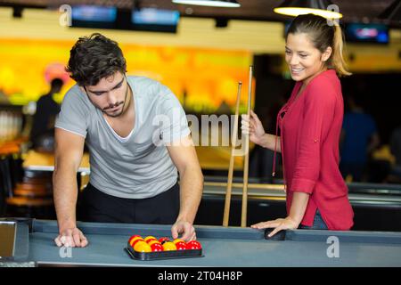 Jeune couple mise en place pour une partie de billard Banque D'Images