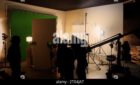 Images silhouettes de la réalisation ou des coulisses de la production vidéo produite dans le studio de cinéma qui incluent tous les équipements de lumière et de caméra professionnels Banque D'Images