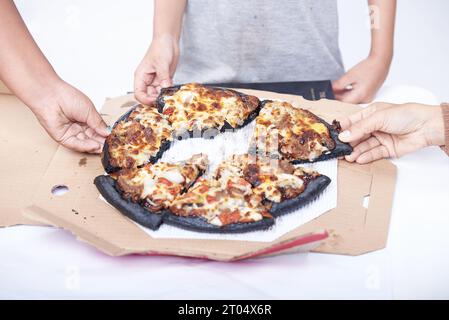 Mains tenant la pizza sur fond blanc, gros plan Banque D'Images