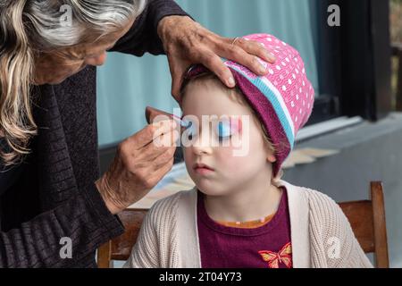 Dans un moment fantaisiste de pur délice, une petite fille se transforme en licorne magique avec son visage peint Banque D'Images