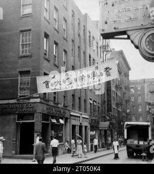 Vue sur la rue dans Chinatown, y compris un mon Hing Co. Storefront et un panneau en chinois. Cette photographie est tirée d'un album personnel non attribué de photographies d'une croisière à New York datée du 29 juin au 13 août 1956. Départ de Liverpool à bord du navire Cunard M.V. Britannic et retour de New York à Southampton à bord du navire Cunard R.M.S. Queen Mary. La taille moyenne des photographies originales était de 4x3 pouces. Banque D'Images