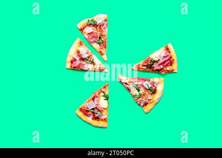 Vue de dessus avec des tranches de pizza prosciutto isolé sur un fond vert. Délicieuse pizza maison. Banque D'Images