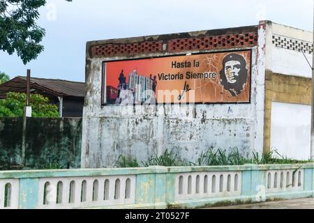 Un panneau d'affichage de Che Guevara dans un vieux bâtiment patiné. Il y a un texte en langue espagnole qui lit : Hasta la Victoria Siempre.Santa Clara, Cuba, 2023 Banque D'Images